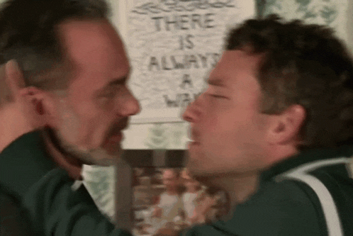 two men are touching noses in front of a sign that says there is always a way