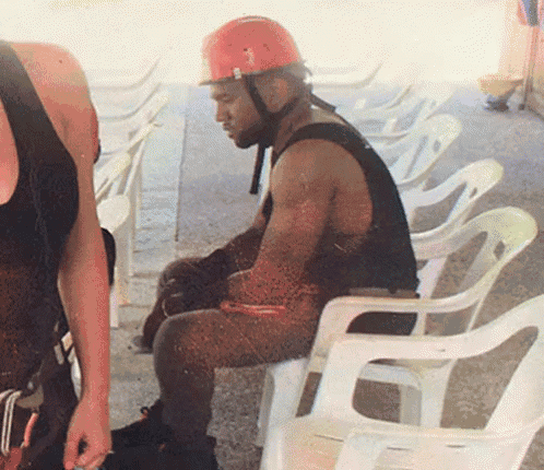 a man wearing a red helmet is sitting in a chair