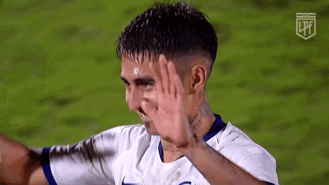 a soccer player with a tattoo on his neck is giving a high five .
