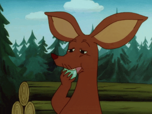 a cartoon kangaroo is eating a green apple in a forest