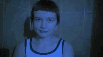 a person in a bathtub with a blue light shining on their face .