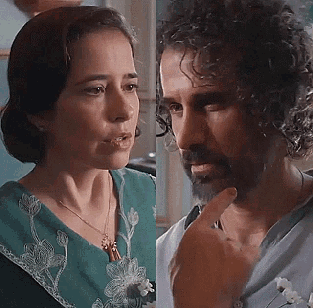 a woman and a man with curly hair are looking at each other . the man is pointing at the woman .