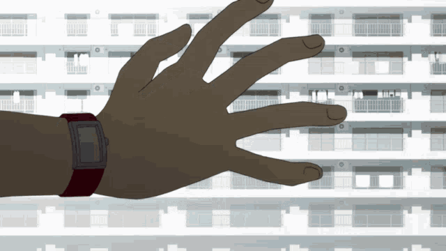 a hand wearing a watch is reaching for something in front of a building