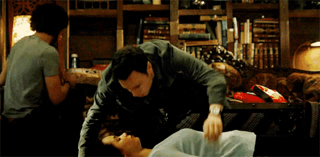 a man is putting something on a woman 's chest in a living room