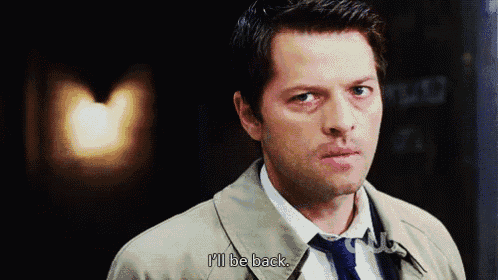 a man in a trench coat and tie is saying i 'll be back