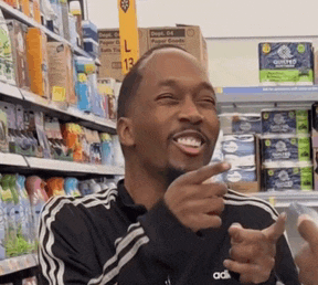 a man wearing an adidas jacket is smiling and pointing at something