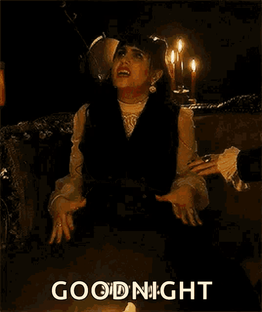 a woman is sitting on a couch with her arms crossed and the words `` good night '' written on the bottom .