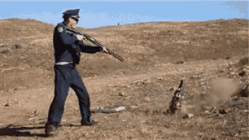 a man in a police uniform is holding a shotgun
