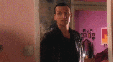 a man in a black jacket is standing in a doorway .