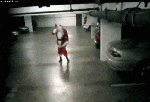 santa claus is walking through a parking garage with cars