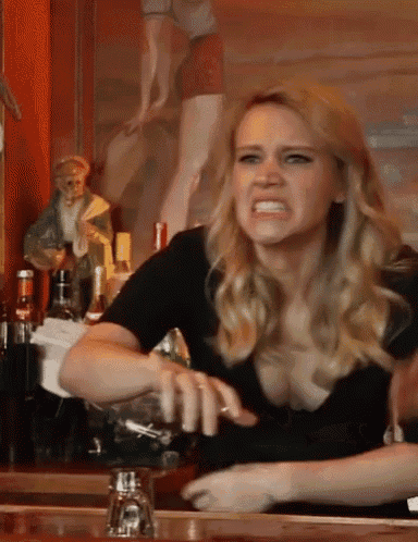 a woman is making a funny face while sitting at a bar counter