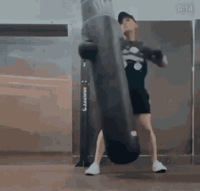 a man is hitting a punching bag with his fist in a gym .