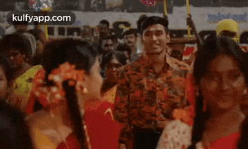 a man and a woman are dancing in a crowd of people at a party .
