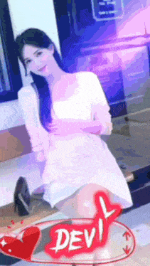 a woman in a white dress is sitting on a bench next to a sign that says devil .