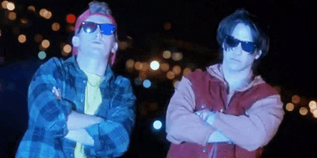 two men wearing sunglasses are standing next to each other