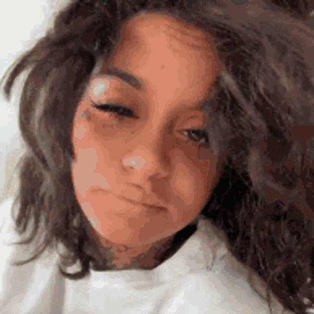 a close up of a woman 's face with a sad look on her face .
