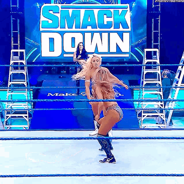 two women are in a wrestling ring with a sign that says smack down