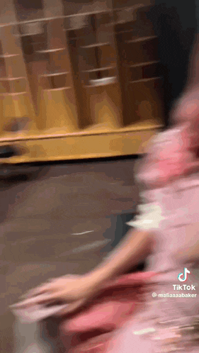 a blurry picture of a person in a pink dress with tik tok written on the bottom