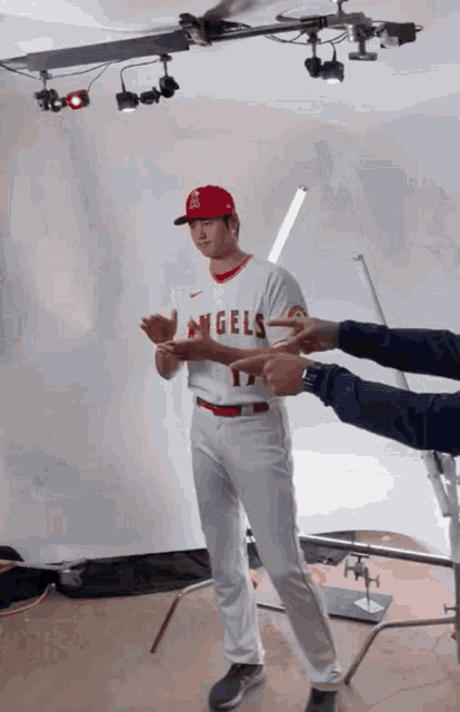 a baseball player wearing a white angels jersey