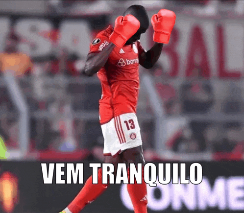 a soccer player wearing red boxing gloves with the words vem tranquilo written below him