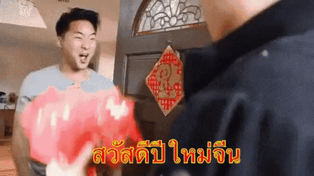 a man is holding a piggy bank in front of a door with a chinese symbol on it .