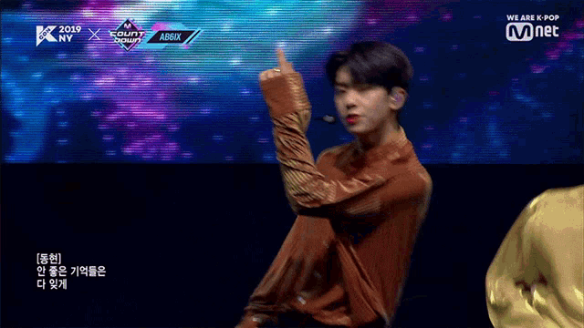 a man giving a thumbs up in front of a screen that says ' we are k pop ' on it