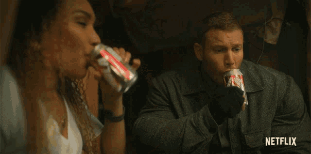 a man is drinking from a can while sitting next to a woman in a tent with the word netflix on the bottom