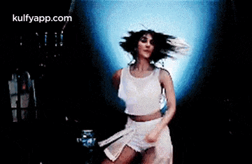 a woman in a white dress is dancing with her arms outstretched .