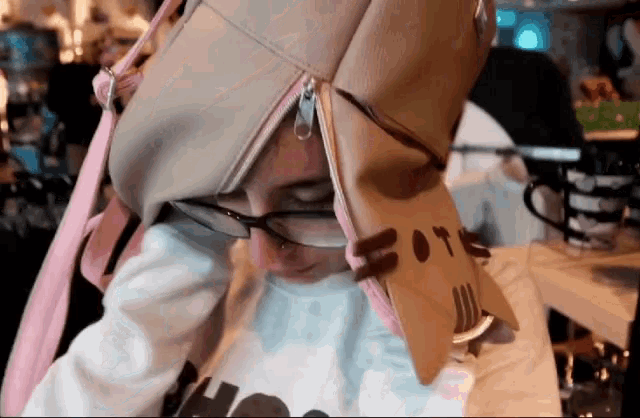 a person wearing glasses and a backpack with a cat face on it