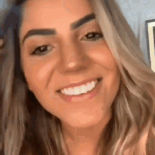 a close up of a woman 's face with a big smile on her face .