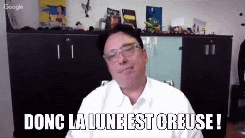 a man wearing glasses and a white shirt says donc la lune est creuse
