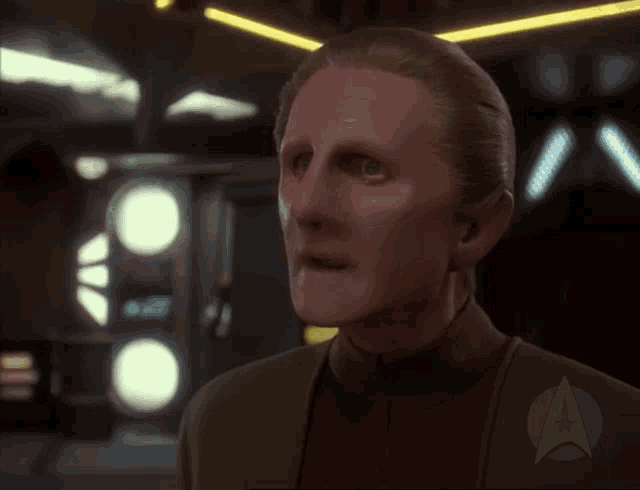 a close up of a man 's face with a star trek logo behind him