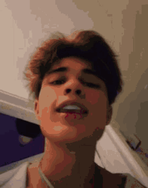 a close up of a young man 's face with his mouth open and his eyes closed .
