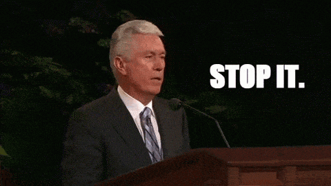 a man in a suit and tie is giving a speech and the words stop it are on the screen