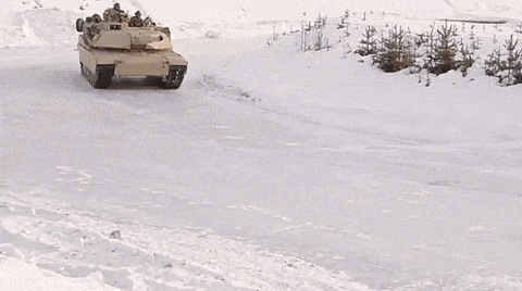 a military tank is driving through a snowy field