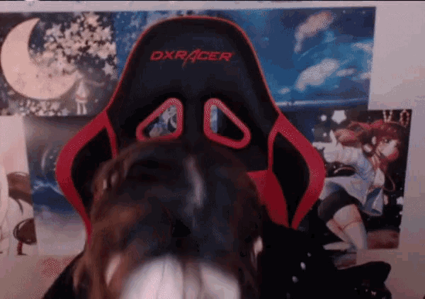 a woman is sitting in a red and black chair that says dxracer