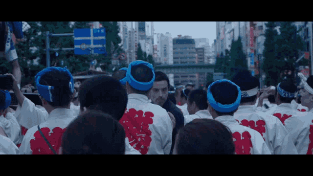 a group of people wearing red and white shirts with chinese writing on the back