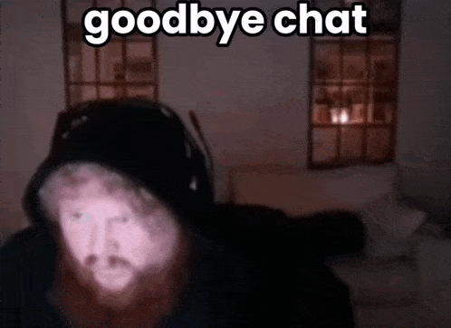 a man with a beard wearing headphones says goodbye chat in a dark room