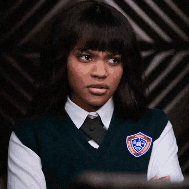 a girl in a school uniform has a badge on her vest that says ' brooklyn college ' on it