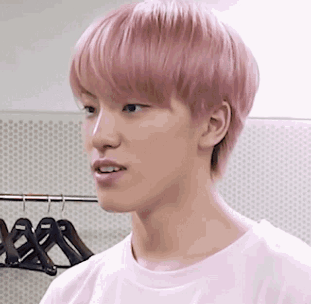 a close up of a person 's face with pink hair