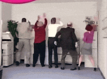 a group of people are dancing in a room in front of a printer