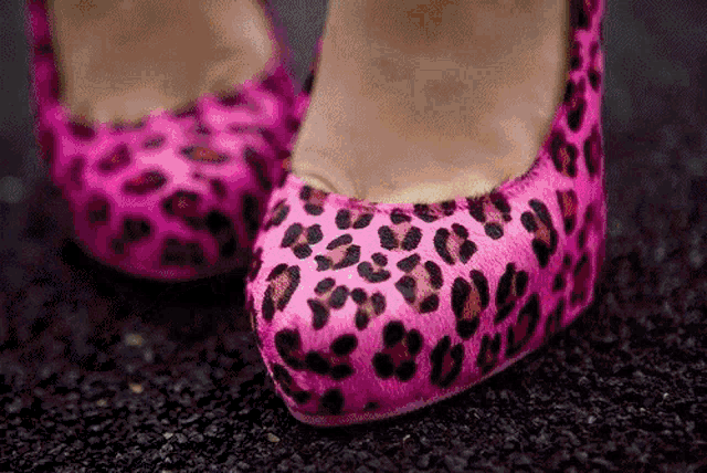 a pair of pink leopard print shoes on a woman 's foot