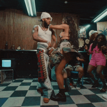 a man and a woman are dancing in a room