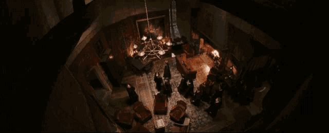 a group of people gathered in a dark room with a chandelier