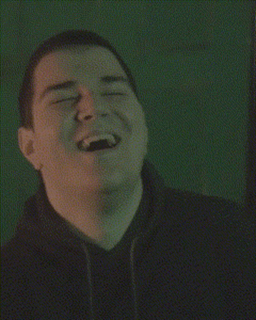 a man in a black shirt is making a funny face