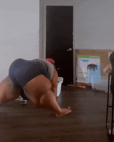 a person is doing push ups in a room with a sign that says ' my pors ' on it