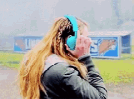 a woman wearing blue headphones is standing in front of a sign that says u.n.
