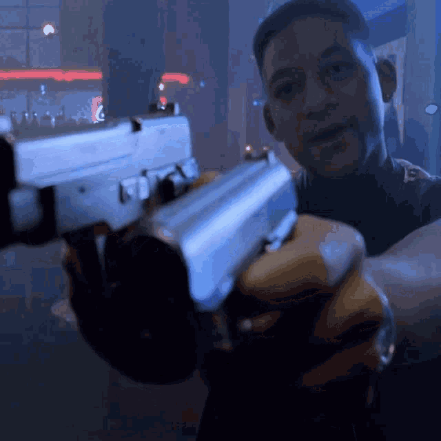 a man is pointing a gun at the camera
