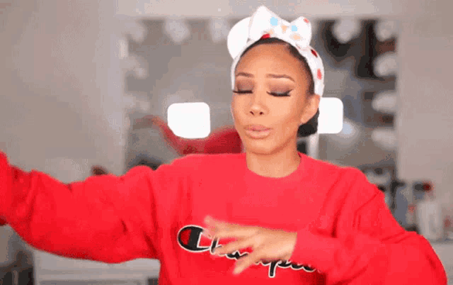 a woman wearing a red champion sweater is dancing