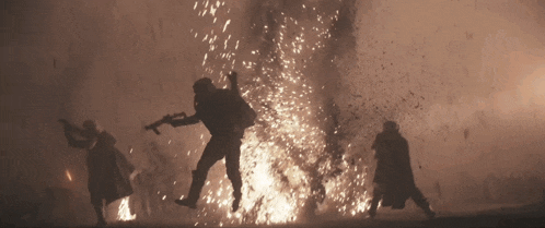 a group of people standing in front of a fire